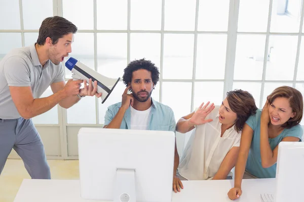 Man yelling through megaphone at business people — Stock Photo, Image