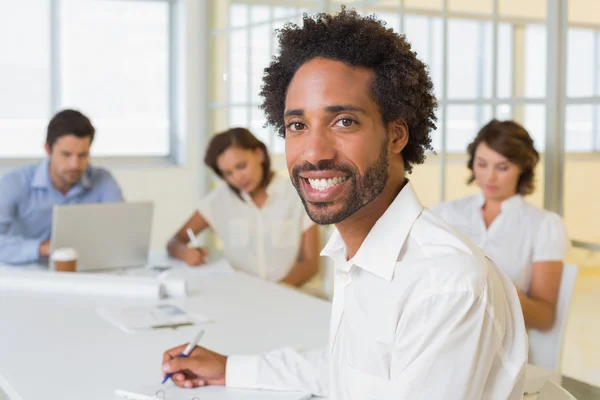 Homme d'affaires souriant avec des collègues en réunion au bureau — Photo