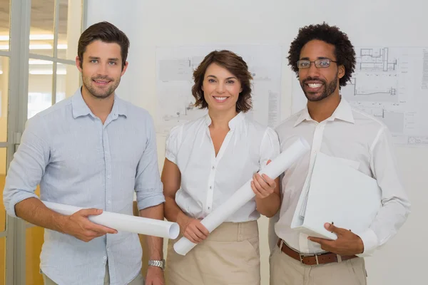 Geschäftskollegen mit Bauplänen im Büro — Stockfoto