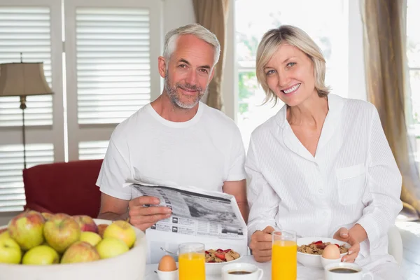 Couple reading newspaper while having breakfast — Stock Photo, Image