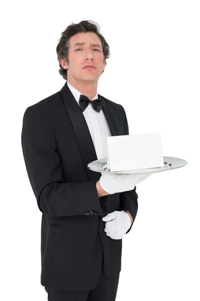 Confident waiter holding tray against white background — Stock Photo, Image