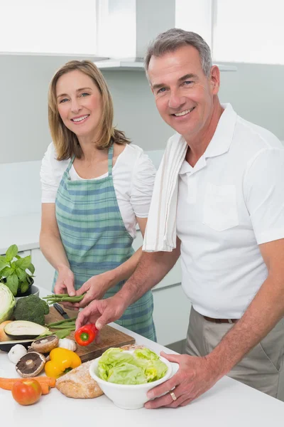 Счастливая пара готовит еду вместе на кухне — стоковое фото