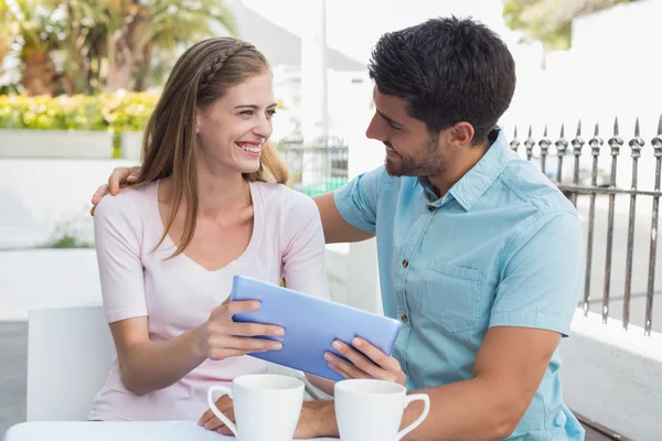 Couple souriant utilisant une tablette numérique au café — Photo