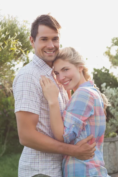 Lächelndes junges Paar umarmt sich im Park — Stockfoto