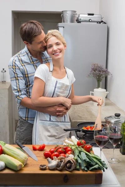 Young couple preparing food together in kitchen — Stock Photo, Image