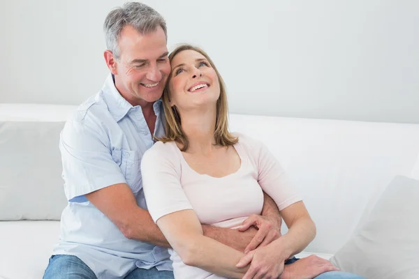 Glückliches Paar, das sich im Wohnzimmer umarmt — Stockfoto