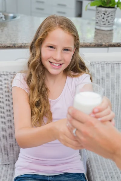 Szczęśliwa młoda dziewczyna odbiera szklankę mleka — Zdjęcie stockowe