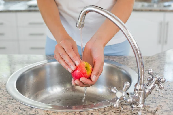 Mitten delen av händerna tvätta äpple på handfat — Stockfoto