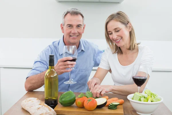 Loving couple with wine glasses in kitchen — Stock Photo, Image