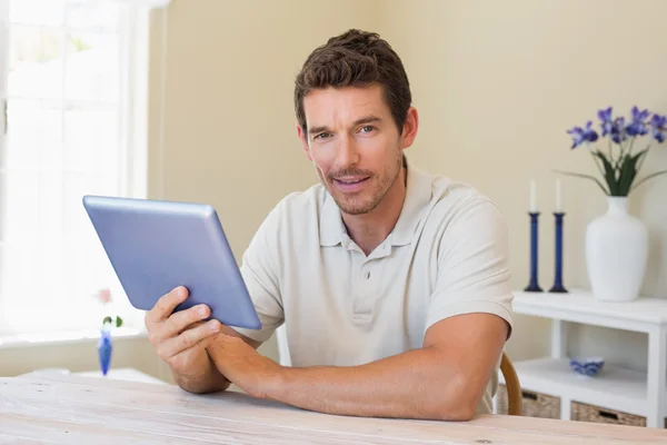 Homme souriant utilisant une tablette numérique à la maison — Photo