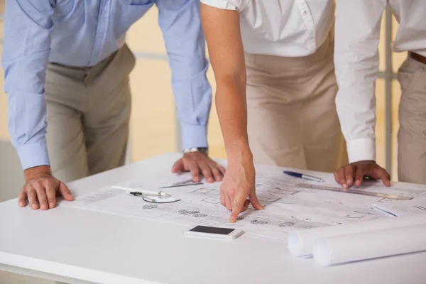 Mid sectie van mensen uit het bedrijfsleven bezig met blauwdrukken — Stockfoto