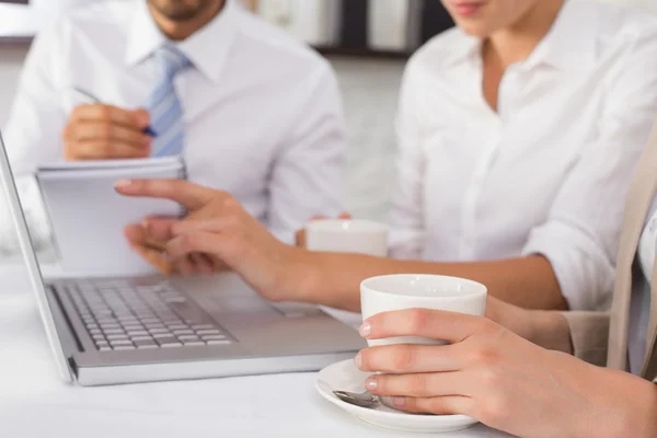 Sección media de tres personas de negocios que utilizan el ordenador portátil juntos — Foto de Stock