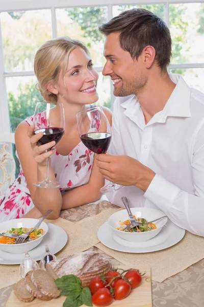 Loving couple with wine glasses looking at each other at dining — Stock Photo, Image