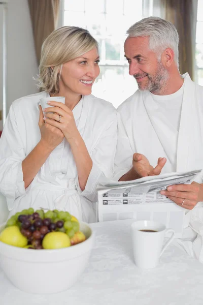 Couple reading newspaper while having breakfast — Stock Photo, Image