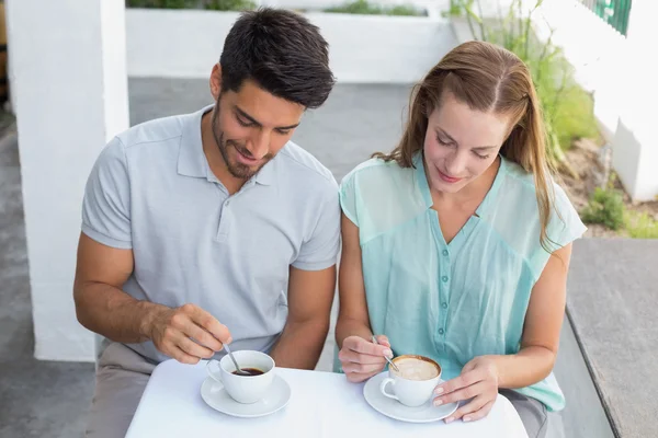 Young couple with coffee cups at cafe — Stock Photo, Image