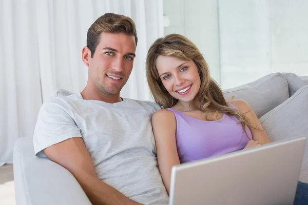 Relaxed couple using laptop on couch — Stock Photo, Image