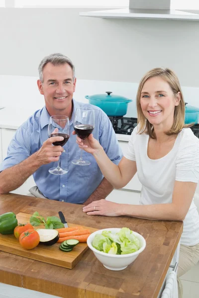 Couple toasting wine glasses in kitchen — Stock Photo, Image