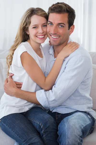 Liebendes junges Paar umarmt sich auf Couch — Stockfoto