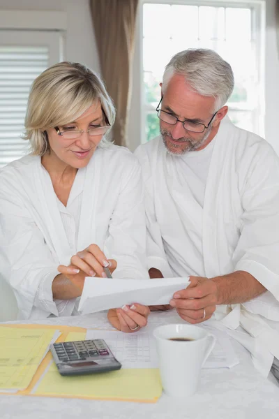 Mature couple sitting with home bills and calculator — Stock Photo, Image