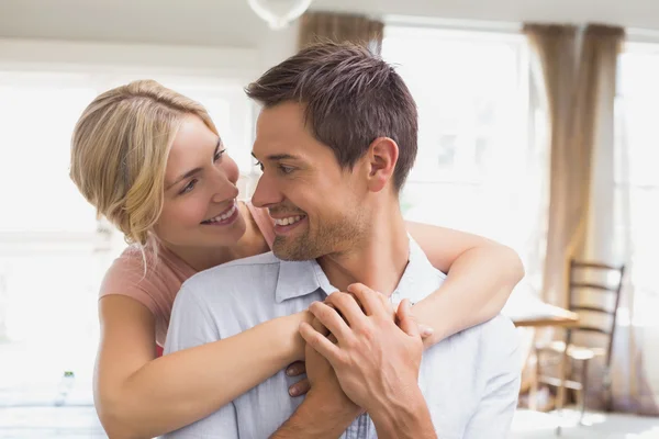 Woman embracing man from behind at home — Stock Photo, Image