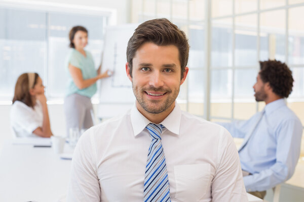 Smiling businessman with colleagues in meeting at office Stock Photo