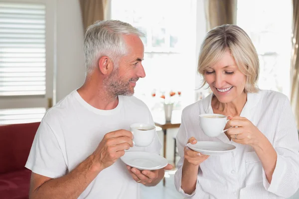 Улыбающаяся зрелая пара с чашками кофе — стоковое фото