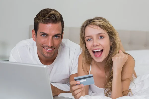 Gelukkige jonge paar doen online winkelen Stockfoto