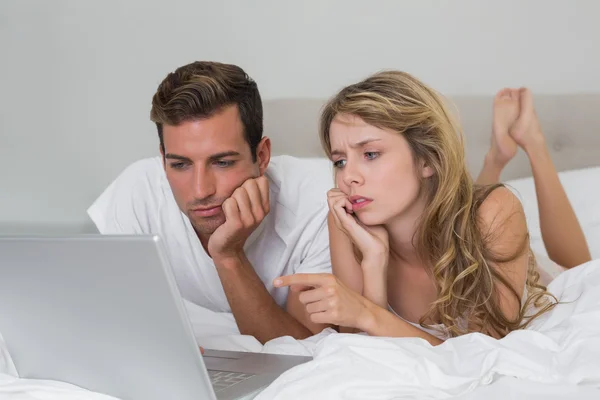 Couple using laptop in bed at home — Stock Photo, Image