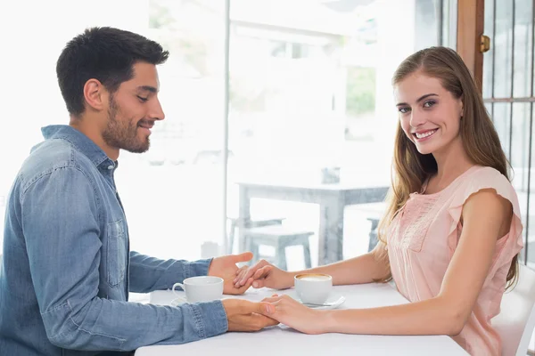 Romantic couple holding hands at coffee shop Royalty Free Stock Images