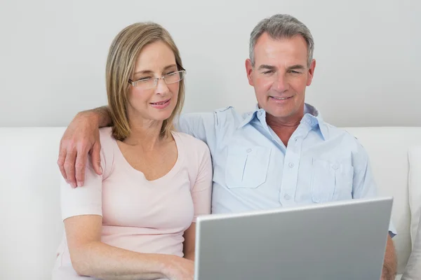 Relaxed couple using laptop at home Stock Picture