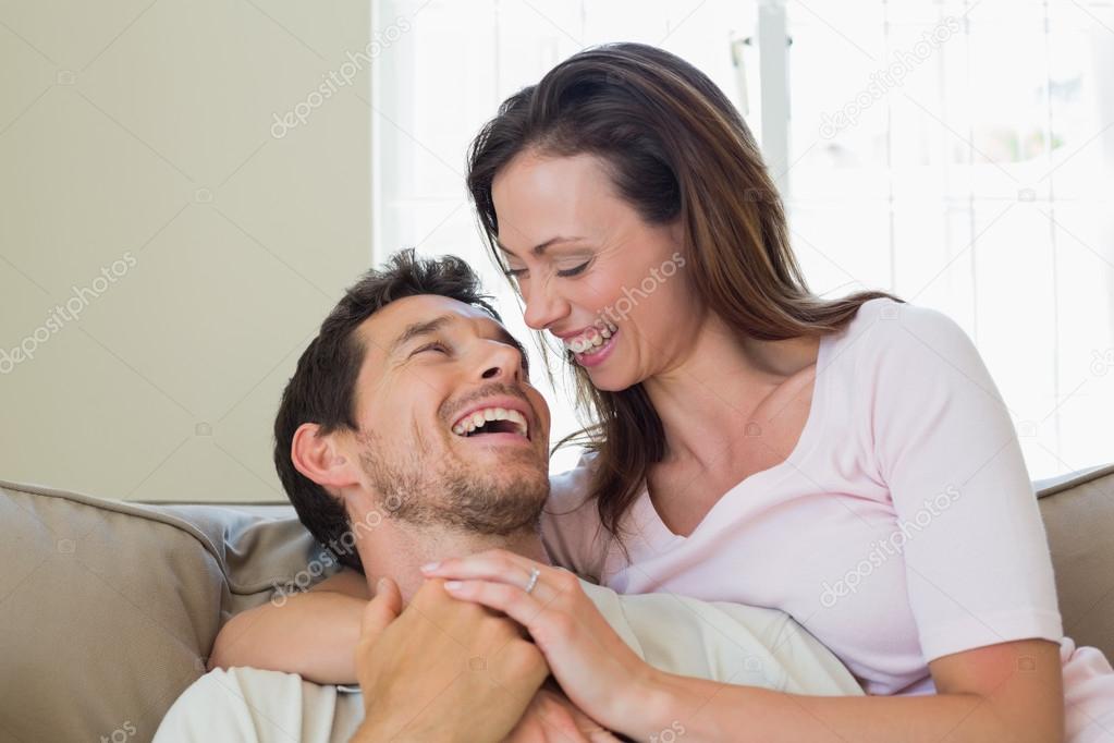 Close-up of cheerful loving couple sitting on couch