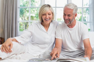 Olgun çift yatak, evde Gazete okurken