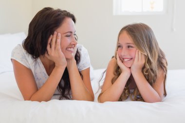 Anne ve kızı yatakta iken birbirlerine bakıyor