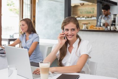 gülümseyen kadın kahve dükkanında istimal hareket eden telefon