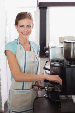 Kahvecide espresso hazırlayan gülümseyen bayan barista.