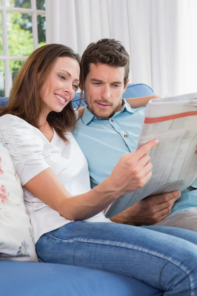 Entspanntes Paar liest Zeitung auf Couch — Stockfoto
