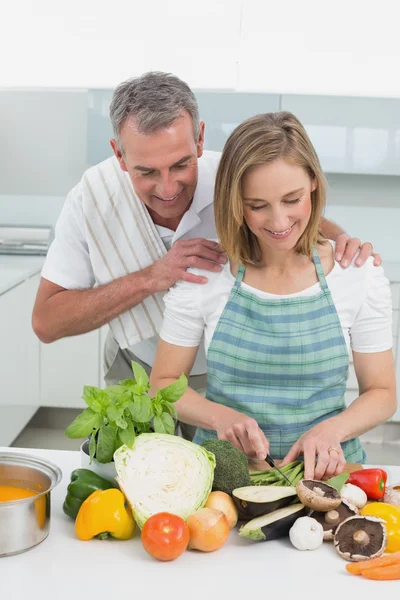 Pareja feliz preparando comida juntos en la cocina —  Fotos de Stock