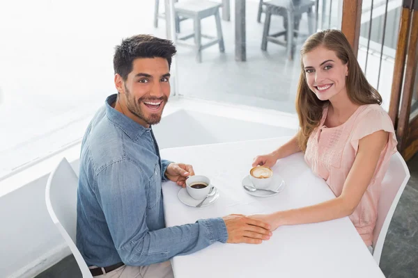Romantikus, fiatal pár kézenfogva kávézóban — Stock Fotó