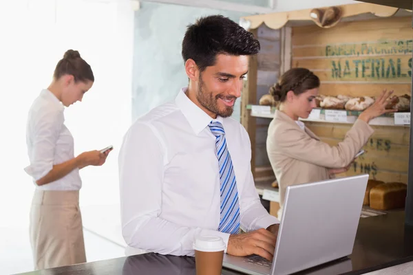 Businessman using laptop in office cafeteria — Stock Photo, Image