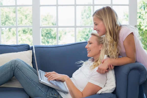 Matka a dcera používat přenosný počítač v obývacím pokoji — Stock fotografie