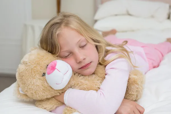 Junges Mädchen schläft mit Stofftier im Bett — Stockfoto