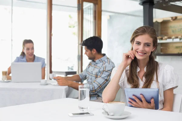 Donna sorridente che utilizza tablet digitale in caffetteria — Foto Stock