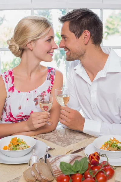 Pareja cariñosa con copas de vino mirándose en el comedor — Foto de Stock