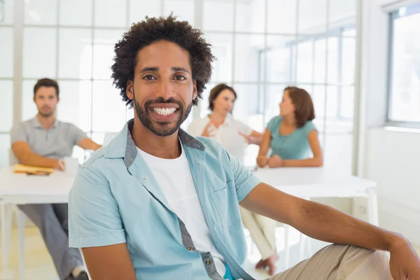Porträtt av en leende affärsman med kollegor i mötet — Stockfoto