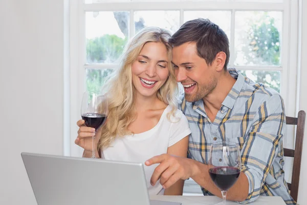 Couple with wine glasses using laptop at home — Stock Photo, Image