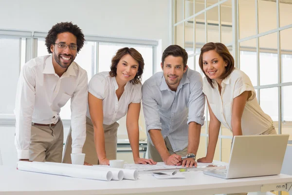 Happy business people working on blueprints at office — Stock Photo, Image