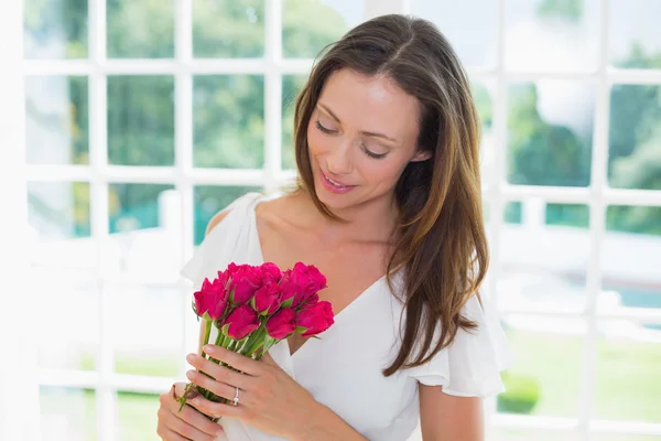 Thoughtful woman with flowers at home — Stock Photo, Image