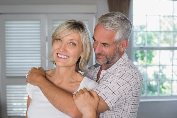 Зрелый мужчина обнимает счастливую женщину — стоковое фото