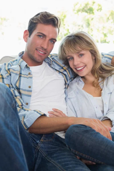 Loving young couple sitting on couch — Stock Photo, Image