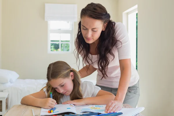 Mujer ayudando a su hija en el dibujo — Foto de Stock